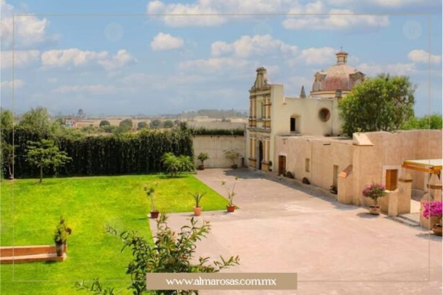 Vista de la explanada principal en Hacienda San Antonio Arenillas, con un área de jardín y su magnífica capilla.